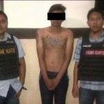 Salah satu tersangka diapit petugas di Mapolsek Sawahan. foto: ekoyono/ BANGSAONLINE