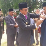 Bupati Pamekasan Baddrut Tamam saat memasangkan piagam dan pita kepada ASN berprestasi dalam upacara peringatan Hari Amal Bhakti (HAB) ke-74. 