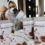 Wilujeng saat mengemas rendang jamurnya. foto: ist.