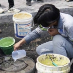 Salah satu mahasiswa ITS saat melakukan pengujian infiltrasi pada inovasi paving porous dari fly ash di Desa Sumberejo, Probolinggo. (Ist)