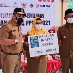 Koordinator IKAPTK Gresik Agustin Halomoan Sinaga menyerahkan simbolis bantuan 3 ton beras untuk warga terdampak PPKM Covid-19. foto: SYUHUD/ BANGSAONLINE