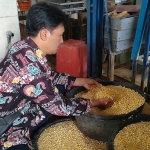 Gatot Siswanto saat mengecek kedelai yang akan dimasak menjadi tahu. foto: MUJI HARJITA/ BANGSAONLINE