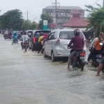 Kendaraan menerobos jalan yang terendam luapan Kali Lamong. foto: SYUHUD/ BANGSAONLINE