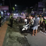 Petugas polisi saat berada di lokasi balap liar yang meresahkan warga Blitar, Minggu (23/1/2022) malam. Foto: BANGSAONLINE.com