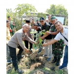 Abdillah Nasih (tengah) secara simbolis menanam bibit pohon kelengkeng saat penyerahan bantuan di Desa Medaeng, Kecamatan Waru. Foto: Ist
