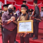 Kadispora Gresik Agustin H. Sinaga bersama Dhanang usai menerima penghargaan dari Gubernur Jatim. foto: SYUHUD/ BANGSAONLINE