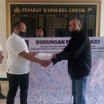 Ketua Orkemas IDR, Choirul Anam (kanan), saat menyerahkan tanda tangan dukungan kepada Kanit Tipikor Satreskrim Polres Gresik, Ipda I Ketut Raisa. Foto: Ist