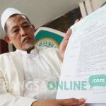 Ketua MUI Jombang menunjukkan fatwa tentang ajaran Gus Jari yang mengaku Nabi Isa. foto: rony suhartomo/ BANGSAONLINE