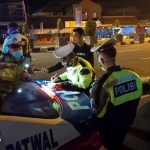 Petugas menilang salah satu pemuda yang kedapatan melanggar lalu lintas.