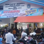 Informasi pasar tetap buka terpampang di Pasar Rakyat Sidoharjo Lamongan.