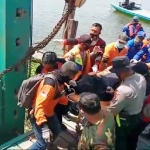 Petugas saat mengevakuasi jasad korban bunuh diri yang ditemukan mengapung di Sungai Bengawan Solo. foto: SYUHUD/ BANGSAONLINE