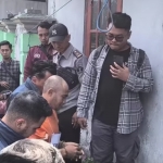 Tersangka Midhol memperagakan adegan saat masuk pintu belakang rumah korban sebelum membunuh Wardatun Thoyyibah. Foto: Ist.