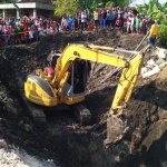 Eskavator mengeruk tanah di lokasi longsor untuk mencari jasad korban.