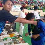 Pengalungan medali untuk Hairul Anwar sebagai juara pertama kategori tanding Putra Remaja.