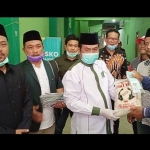 Ketua DPC PKB Gresik Moh.Qosim didampingi Ketua DPRD Fandi Akhmad Yani dan Fraksi PKB DPRD saat membagikan beras kepada sopir lyn. foto: SYUHUD/ BANGSAONLINE