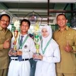 Kepala MAN 1 Kota Malang H. M. Husnan didampingi Waka Kesiswaan Iwan Setiawan, mengapit dua siswa juara pencak silat internasional di ITB Bandung. foto: IWAN IRAWAN/ BANGSAONLINE