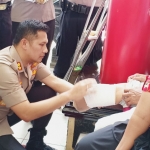 Kapolres Blitar AKBP Budi Hermanto saat melakukan pengukuran kaki palsu kepada salah satu penyandang disabilitas.