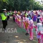 Para siswa Bahrul Ulum Desa Genukwatu, Kecamatan Ngoro, Kabupaten Jombang saat ikut perkenalan rambu-rambu lalu lintas. foto: ROMZA/ BANGSAONLINE