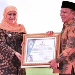 Gubernur Jawa Timur Khofifah Indar Parawansa memberi penghargaan kepada Bupati Lamongan Fadeli. Foto: ist/bangsaonline.com