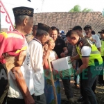 Kapolres Jombang, AKBP Agung Marlianto (rompi hijau) saat menyerahkan bantuan kepada warga Dusun Nggembrong, Desa Japanan, Kecamatan Mojowarno, Jumat (10/8/2017). foto: ROMZA/ BANGSAONLINE