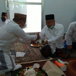 Prof Dr KH Asep Saifuddin Chalim, MA saat menerima potongan tumpeng dari Rais Syuriah PCNU Batang KH Ahmad Manaf Syair di Klinik NU Limpung Batang Jawa Tengah, Sabtu (28/8/2021).Foto: mma/bangsaonline.com