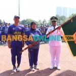 Bupati Gresik, Fandi Akhmad Yani, saat menyerahkan bendera kepada Ketua KONI Gresik, Anis Ambiyo Putri, saat pelepasan kontingen. Foto: SYUHUD/BANGSAONLINE