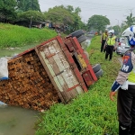 Kondisi truk yang terguling ke sungai kawasan Jalan Raya Gedangan, Desa Wedi, Kecamatan Gedangan, Sidoarjo, Senin (11/1/2021).