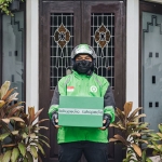 Driver Gojek sedang membawa paket Tokopedia untuk pelanggan. (foto: ist)