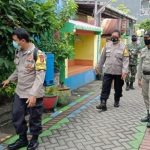 Jajaran Polres Gresik saat melakukan penyemprotan disinfektan di permukiman padat penduduk.