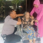 Aipda Purnomo saat memberikan bantuan kursi roda kepada Mbah Dasina.