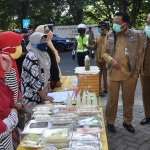 Bupati Sambari dan Wabup Qosim saat menjual paket sembako murah. (foto: SYUHUD/ BANGSAONLINE)
