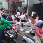 Anggota Merpati Putih saat bagi-bagi takjil kepada pengguna jalan. (Ist).