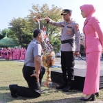 PROSESI KENAIKAN PANGKAT: Kapolres Madiun AKBP Anton Prasetyo sedang menyiramkan air kembang kepada anggota yang menerima kenaikan pangkat.