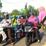 Polwan dari Polres Situbondo saat membagi-bagikan bunga dan cokelat kepada para pengendara. foto: MURSIDI/ BANGSAONLINE