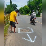 Warga menandai jalan yang berlubang.