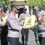 Wakapolres Situbondo menyerahkan bantuan beras secara simbolis kepada kapolsek jajaran untuk disebar kepada warga. (foto: ist)