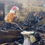 Petugas saat mengevakuasi kandang sapi dan dapur rumah yang terbakar di Pamekasan.