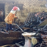 Petugas saat mengevakuasi kandang sapi dan dapur rumah yang terbakar di Pamekasan.