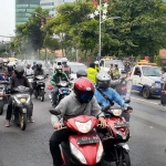 Penyemprotan disinfektan kepada pengendara yang masuk ke Kota Surabaya di jalan Ahmad Yani.