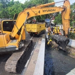 Petugas saat melakukan pengerukan di Kaliotik Depan Pasar Ikan Lamongan. 