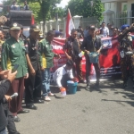 Para pendemo saat berorasi di depan pintu gerbang Kajari Trenggalek. foto: HERMAN/ BANGSAONLINE.