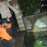 Petugas memeriksa parit yang diduga menjadi lokasi jatuhnya korban.