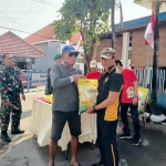 Kapolsek Buduran, Kompol Subadri saat mendistribusikan beras murah. (Ist)