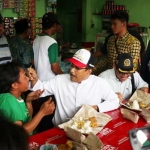 Tak canggung, layaknya seorang ayah kepada anaknya. Gus Ipul secara spontan menyuapi Sofyan, salah satu pedagang di Pasar Benowo. 
