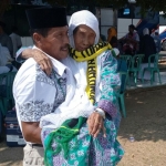 Jamaah haji saat dibopong keluarganya usai kedatangannya di lokasi penjemputan. 