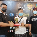 Ketua DPRD Kabupaten Kediri, Dodi Purwanto (kiri) saat menyerahkan piala juara pertama kepada pemenang dari Surabaya didampingi oleh Yakup Bastian, Ketua Sentra Guppy Kediri. (foto: MUJI HARJITA/ BANGSAONLINE)