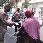 Petugas gabungan saat melakukan operasi nonyustisi, salah satunya dengan membagikan masker kepada pengguna jalan. Foto: Ist