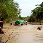 Warga Gorekan Lor, Desa Cermenlerek, Kecamatan Kedamean saat menyeberangkan keranda jenazah menggunakan ban bekas di anak Kali Lamong. foto: ist.