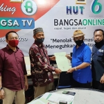 Ahmad Djauhar (kaos biru dan pakai topi), Anggota Dewan Pers yang juga Ketua Komisi Penelitian, Pendataan, dan Ratifikasi Pers menunjukkan berkas yang sudah diverifikasi bersama H. Abdurrahman Ubaidah, Pemimpin Redaksi BANGSAONLINE.com, didampingi M Mas