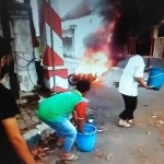 Beberapa warga saat berusaha memadamkan api.